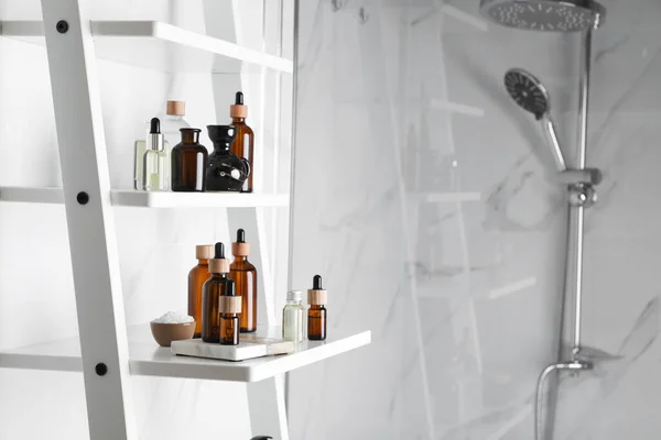 バスルームの白い棚ユニット上のエッセンシャルオイル およびその他の化粧品 テキストのスペース — ストック写真