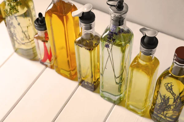 Flaschen Mit Verschiedenen Speiseölen Auf Weißem Holztisch Nahaufnahme — Stockfoto