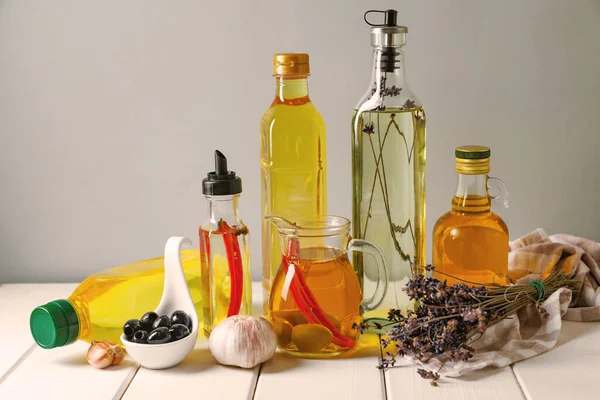 Verschiedene Speiseöle Und Zutaten Auf Weißem Holztisch Vor Grauem Hintergrund — Stockfoto