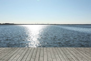 Güneşli bir günde, nehrin yanındaki ahşap terasın güzel manzarası.
