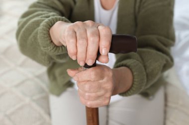 Elderly woman with walking cane indoors, closeup. Home care service