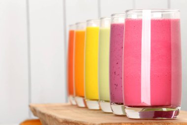 Beyaz ahşap arka plana karşı birçok farklı lezzetli smoothie, metin için boşluk