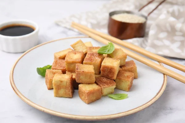 stock image Plate with delicious fried tofu and basil on table, closeup