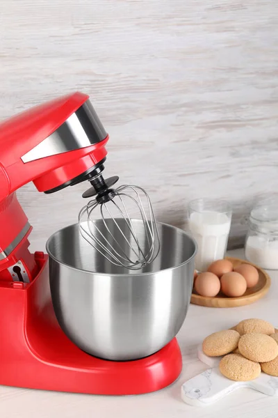 Composition with modern red stand mixer and different products on white table