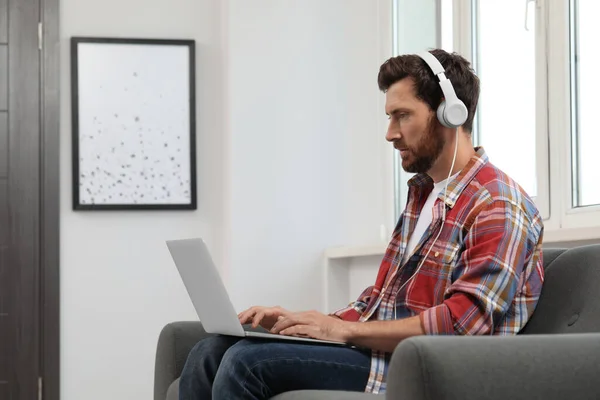 Bonito Barbudo Homem Com Fones Ouvido Usando Laptop Dentro Casa — Fotografia de Stock