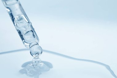 Beyaz arka planda pipetten damlayan yüz serumu, yakın plan. Metin için boşluk