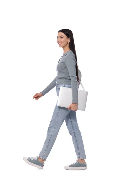 带着手提电脑在白色背景上行走的年轻女子 — 图库照片