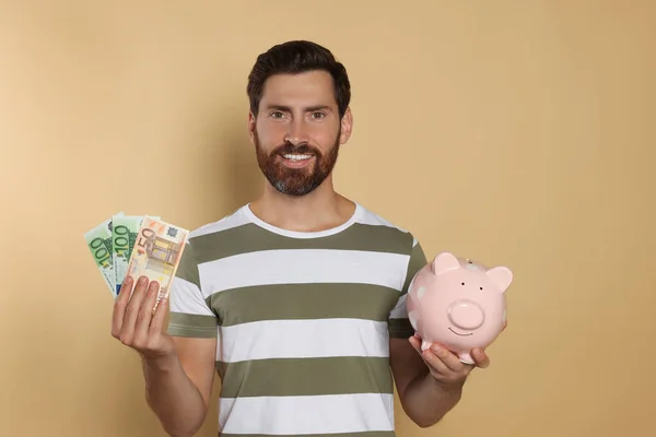 Happy Man Money Ceramic Piggy Bank Beige Background — Stock Photo, Image