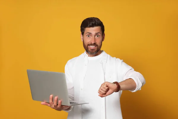 Emotionele Man Met Laptop Die Tijd Controleert Oranje Achtergrond Laat — Stockfoto