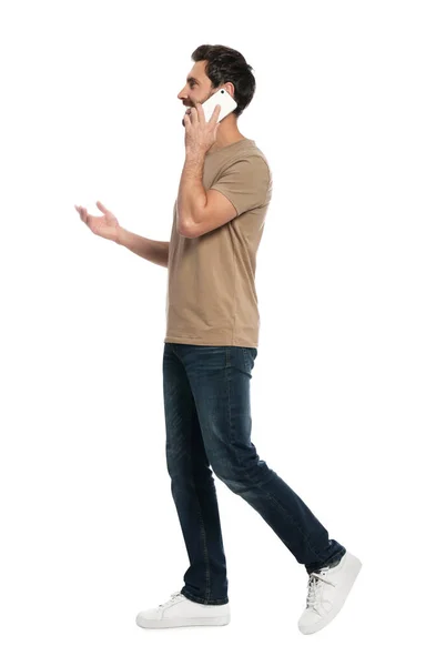 Schöner Mann Spricht Auf Smartphone Während Vor Weißem Hintergrund Läuft — Stockfoto