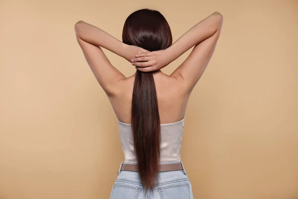 Schöne Frau Mit Starken Gesunden Haaren Auf Beigem Hintergrund Rückseite — Stockfoto