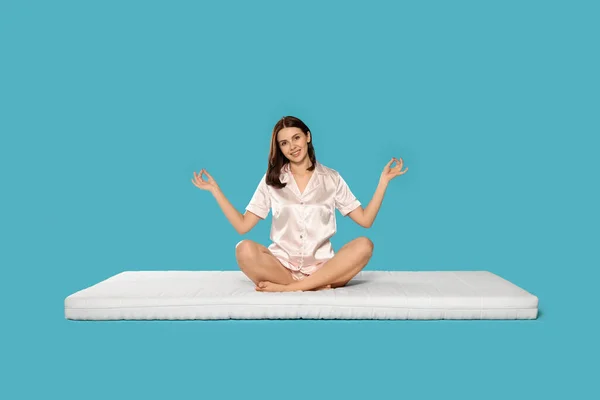Junge Frau Meditiert Auf Weicher Matratze Vor Hellblauem Hintergrund — Stockfoto