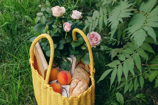 Gelber Weidensack Mit Rosen Pfirsichen Buch Und Baguette Auf Grünem — Stockfoto