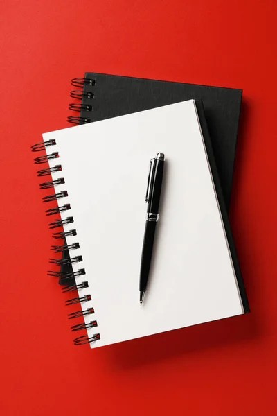 Notitieboekjes Pen Rode Achtergrond Bovenaanzicht — Stockfoto