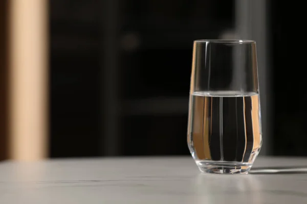 Stock image Glass of pure water on white table indoors, space for text