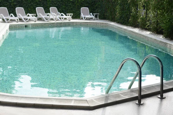 Ladder with grab bars in outdoor swimming pool