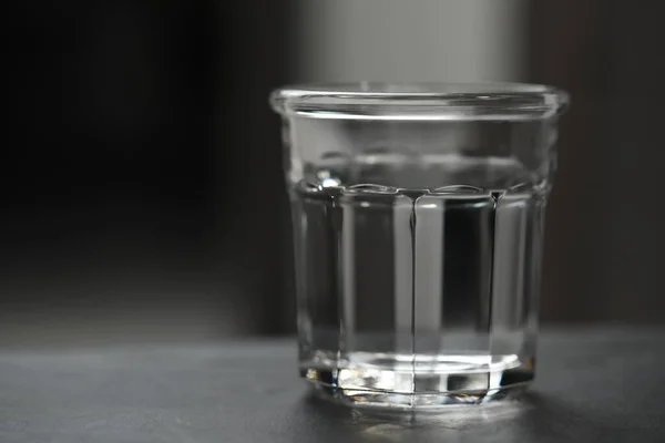 Egy Pohár Tiszta Víz Fekete Asztalon Homályos Háttérrel Hely Szövegnek — Stock Fotó