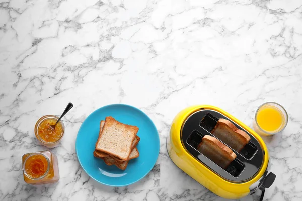 黄色烤面包机 烤面包 一杯果汁和果酱在白色大理石桌子上 案文的篇幅 — 图库照片