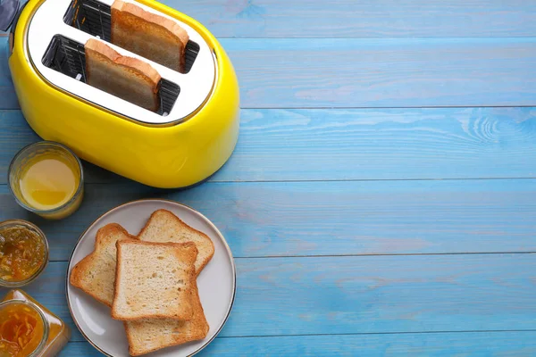 黄色烤面包机 烤面包 一杯果汁和果酱放在浅蓝色的木制桌子上 案文的篇幅 — 图库照片
