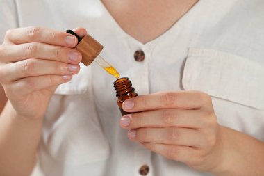 Özgeçmiş olarak gerekli yağ şişesine sahip genç kadın, yakın plan.