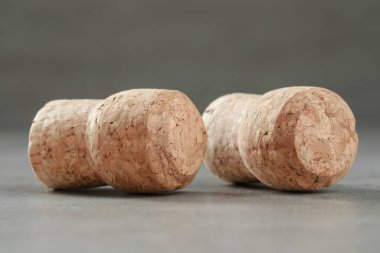 Şarap şişelerinin tıpaları açık gri masada, yakın plan.