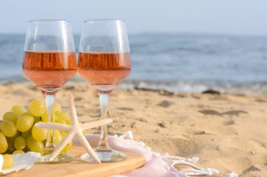 Gül şarabı ve kumlu sahilde atıştırmalık bardaklar. Metin için boşluk