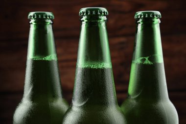 Many bottles of beer on wooden background, closeup