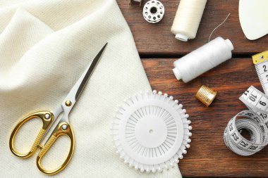 Ahşap masa üzerinde iplikler ve diğer dikiş malzemeleri, düz yatıyordu