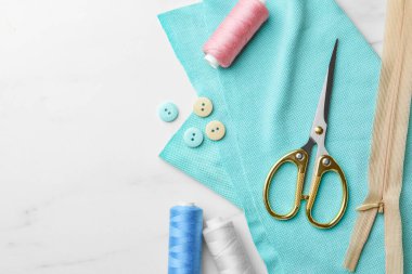 Beyaz mermer masa üzerinde iplikler ve diğer dikiş malzemeleri düz yerde. Metin için boşluk