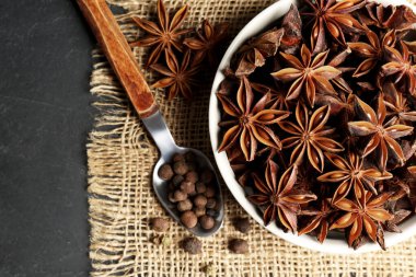 Aromatik anason yıldızları ve biberli kase koyu masa, düz yatıyordu.