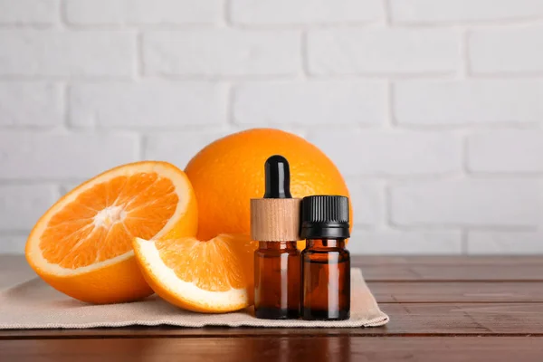 Botellas Aceite Esencial Con Naranjas Sobre Mesa Madera Contra Pared — Foto de Stock
