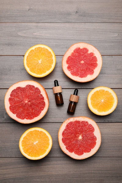 木のテーブルの上に柑橘類の精油と新鮮な果物のボトル フラットレイアウト — ストック写真