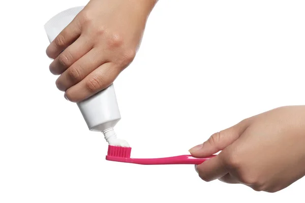 白い背景にブラシに歯磨き粉を適用する女性 クローズアップ — ストック写真