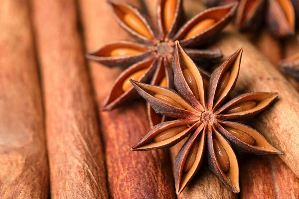 stock image Aromatic anise stars on cinnamon sticks as background, closeup