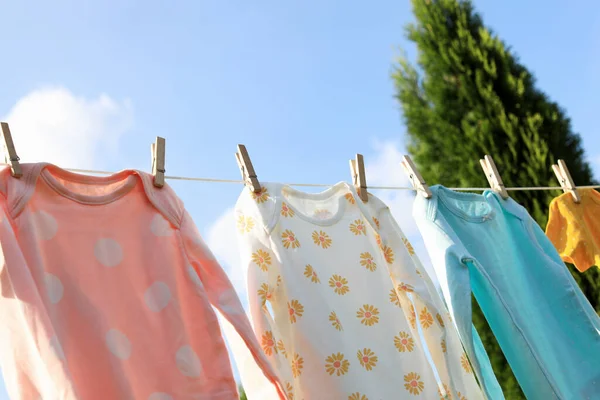 庭の洗濯ラインにかかってきれいな赤ちゃんのスパイ 服を乾かす — ストック写真