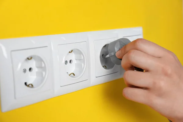 Woman Inserting Plug Power Socket Yellow Wall Closeup Electrical Supply — Stockfoto