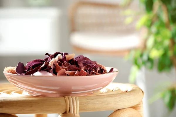 Aromatic potpourri of dried flowers in bowl on wicker table indoors