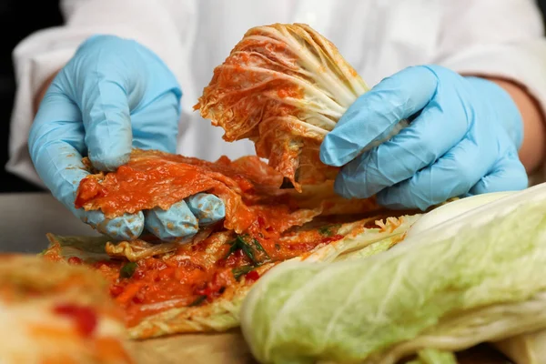 stock image Woman preparing spicy cabbage kimchi at table, closeup