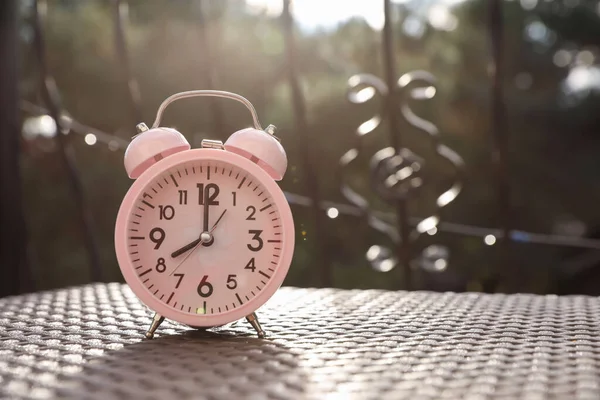 晴れた朝に屋外のテーブルの上にピンクの目覚まし時計 テキストのスペース — ストック写真