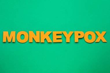 Yeşil arkaplanda parlak harflerden oluşan kelime Maymun Çiçeği, üst görünüm