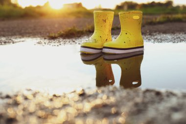 Açık havada sarı lastik botlar, mesaj için yer. Sonbahar yürüyüşü