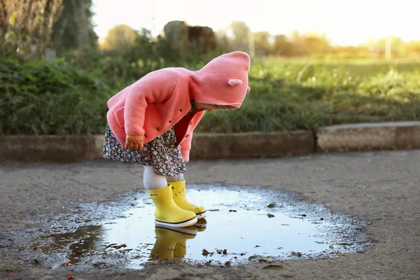 屋外の水たまり テキストのためのスペースに立ってゴムブーツを身に着けている少女 秋の散歩 — ストック写真