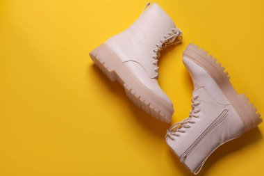 Sarı arka planda düz bir çift şık ayakkabı. Metin için boşluk