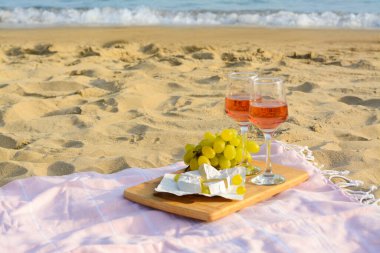 Gül şarabı ve kumlu sahilde atıştırmalık bardaklar. Metin için boşluk