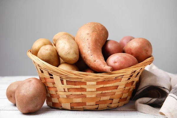 Verschillende Soorten Verse Aardappelen Rieten Mandje Witte Houten Tafel — Stockfoto