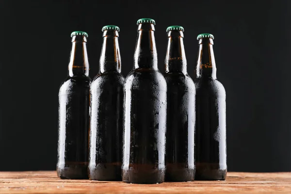 Muitas Garrafas Cerveja Mesa Madeira Contra Fundo Escuro — Fotografia de Stock