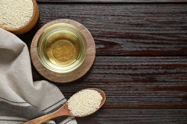 Cam kasede taze susam yağı ve koyu ahşap masadaki tohumlar. Metin için boşluk