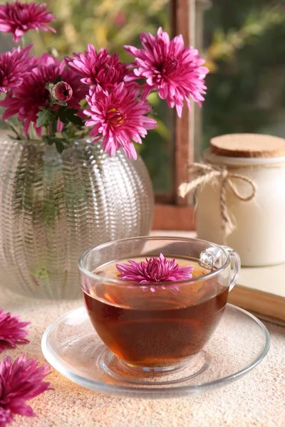 Schöne Chrysanthemenblüten Und Eine Tasse Tee Auf Einem Beige Strukturierten — Stockfoto