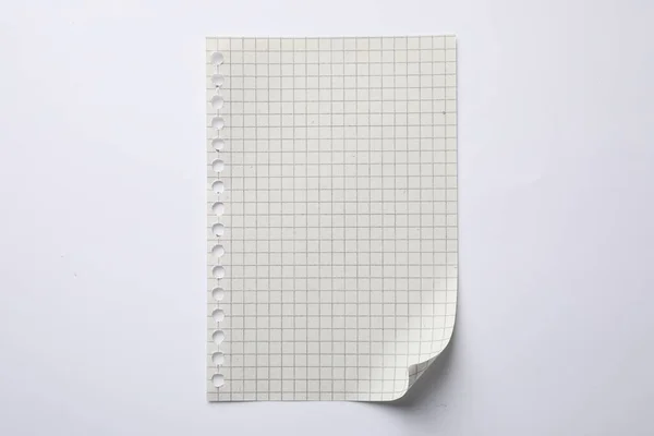 Checkered sheet of paper on white background, top view