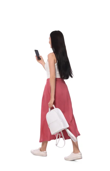 Jovem Mulher Usando Smartphone Enquanto Caminha Sobre Fundo Branco — Fotografia de Stock